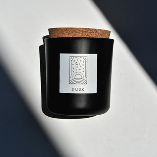 Dusk candle in black apothecary glass with cork top.