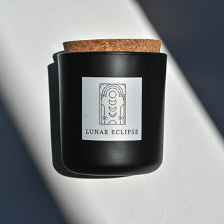Lunar Eclipse candle in black apothecary glass with cork top.