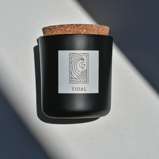 Tidal candle in black apothecary glass with cork top.