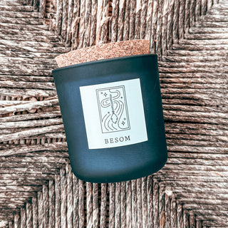 frosted blue tumbler candle with cork top and graphic art label titled besom and witches broom in the sky